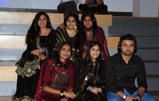 A group of students sitting in the SLC, some in traditional dress