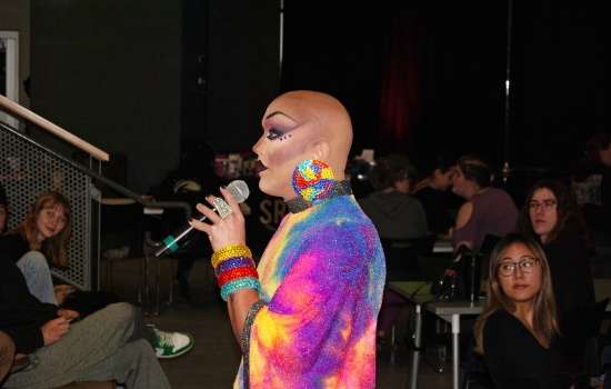 Drag queen Sabin speaks to the crowd through a microphone