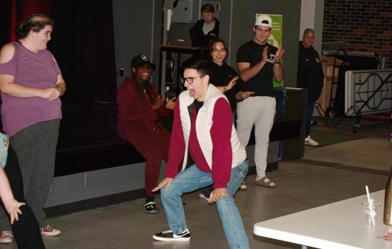 A student participates in a twerking contest in the SLC while other students look on