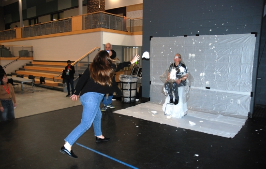 A student thows pie at a faculty member