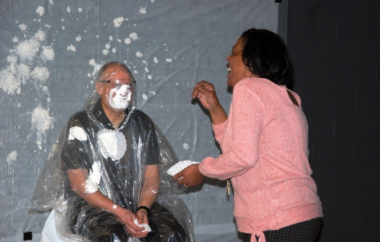 A student thows pie at a faculty member