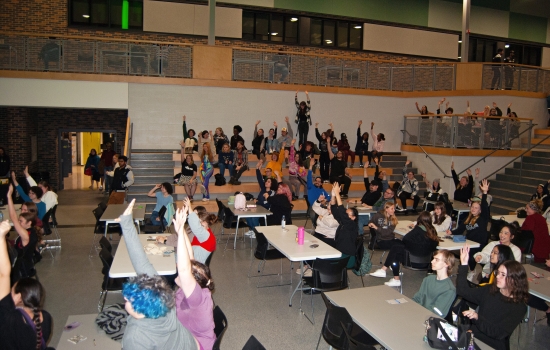 A crowd of students all raising their hands to be chosen by Sabin
