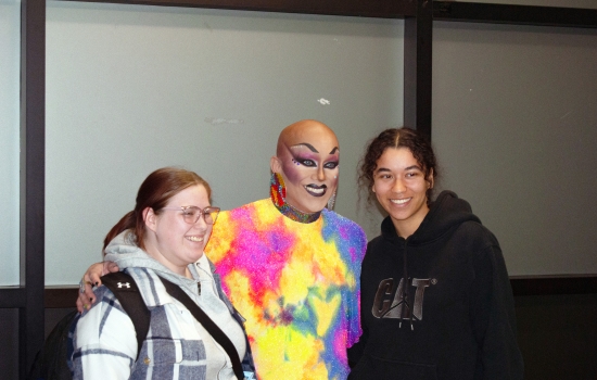 Sabin poses in the hallway with two students