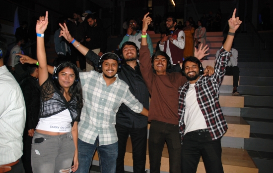 A happy group of students with their hands in the air