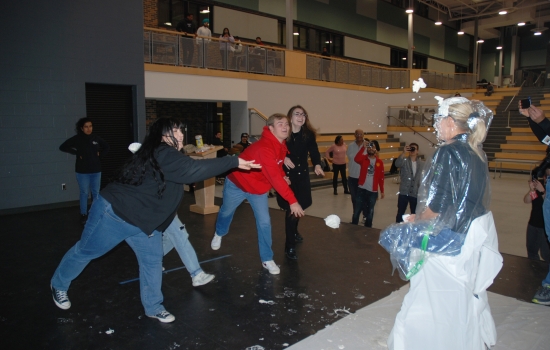 Three students throw pie at a faculty member at the same time