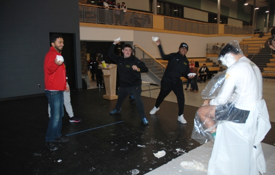 Rishi and two other students throw pies at George