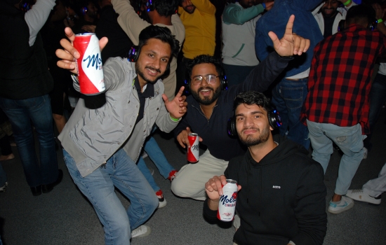 3 students on the dance floor holding beverages