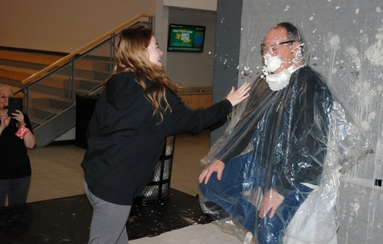 A student thows pie at a faculty member