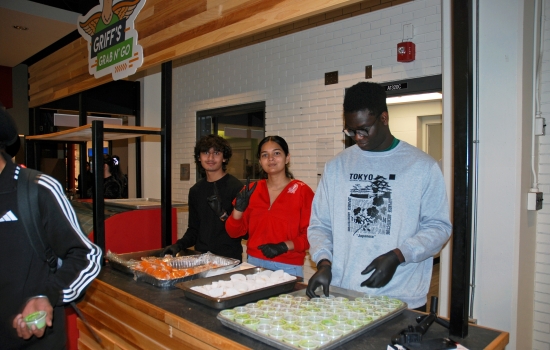 Harnoor and student staff hand out treats at the Grab N' Go Kiosk