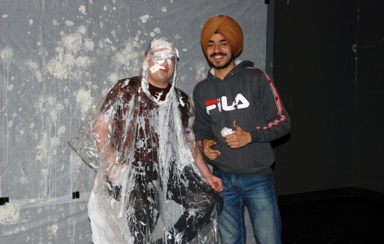 Pratham and a pie-covered faculty member smile for the camera