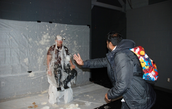 A student thows pie at a faculty member