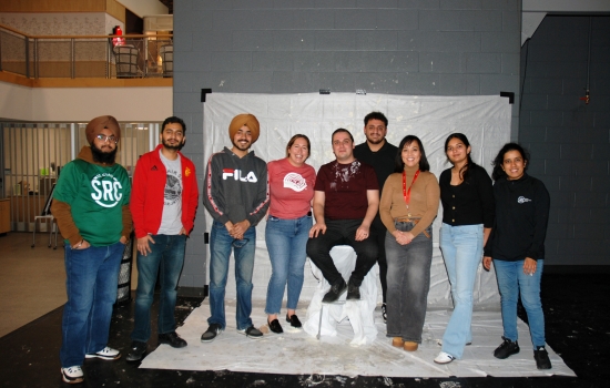SRC board members and faculty pose together for a photo on the SLC stage