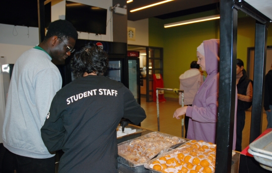 Two student staff hand out treats at the Grab N' Go Kiosk