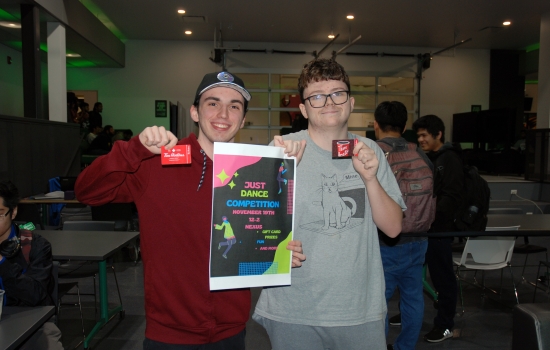 Two winning students pose with their gift card prizes and the event poster