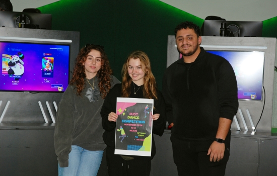 Aida, Ashley and Ali post for a photo with the event poster