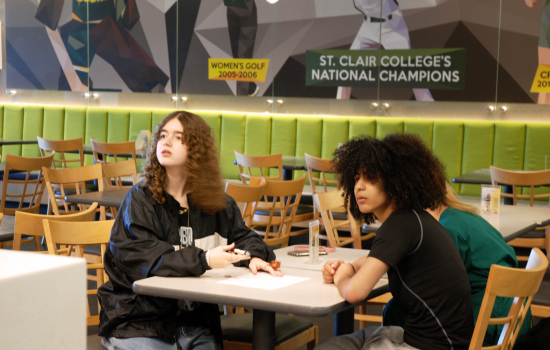 Two students sitting in Griff's, a campus pub, focused intently on the trivia question