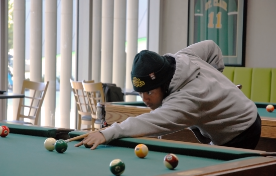 A student playing pool at Griff's