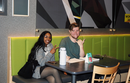 Two students sitting in Griff's smiling for the camera