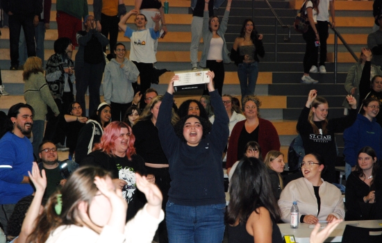 A student cheers and holds up her sex toy prize