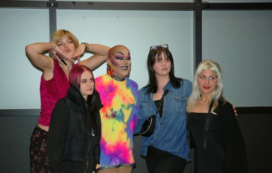 A group of students posing for a photo with Sabin in the hallway