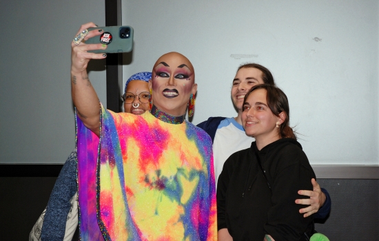 A group of students posing for a photo with Sabin in the hallway
