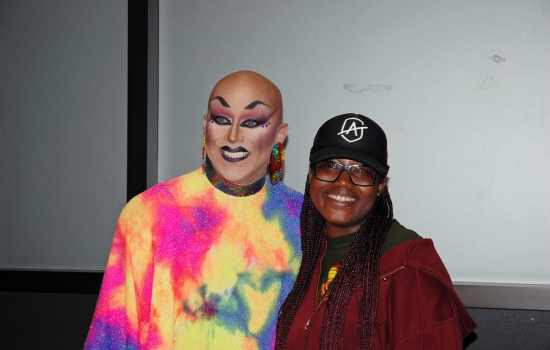 A student smiles and poses for a photo with Sabin