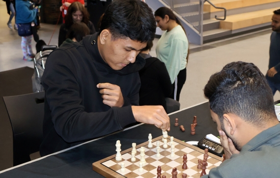 Rishi vs student chess game on the SLC stage