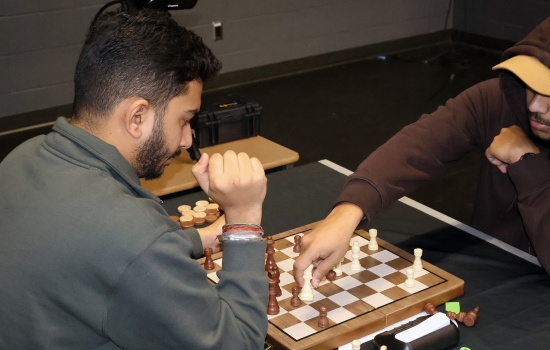 Rishi vs student chess game on the SLC stage
