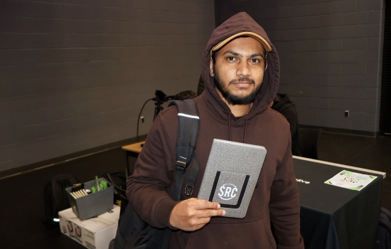 A winning student with his choice of prize, an SRC notebook