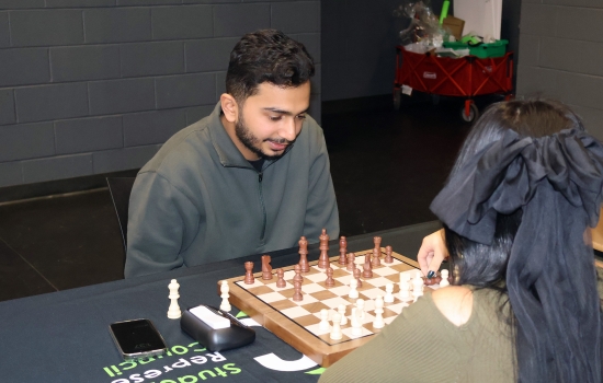 Rishi vs student chess game on the SLC stage