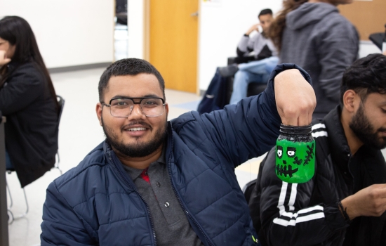 A student proudly shows off his painted frankenstein jar