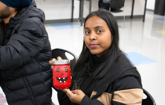 A student proudly shows off his painted jackolatern jar
