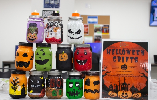 A tower of halloween-themed jars painted by students
