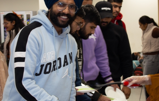 A student smiles for the camera as he fills his plate