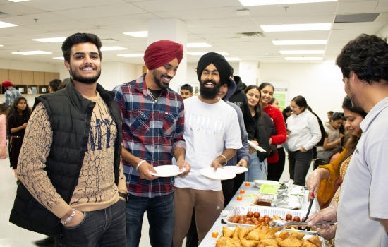 Students smiling with their plates at the serving table