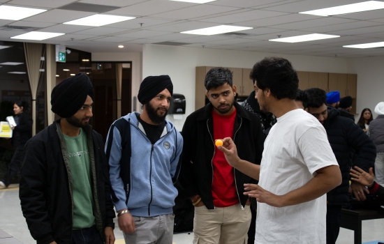 Kunal explains how to play to 3 students