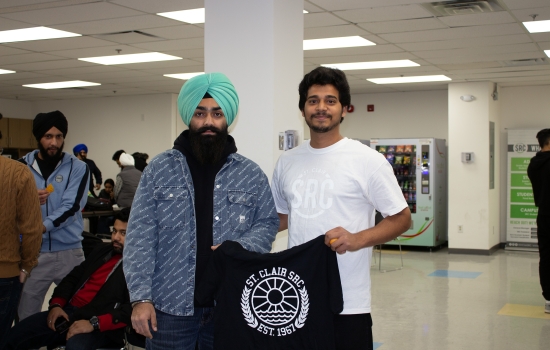 Kunal poses with a student who won an SRC t-shirt