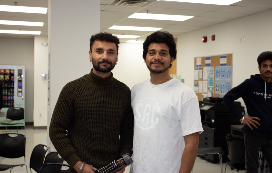 Kunal poses for a photo with a student who won a water bottle