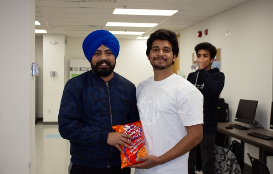Kunal poses with a student who won a bag of chips