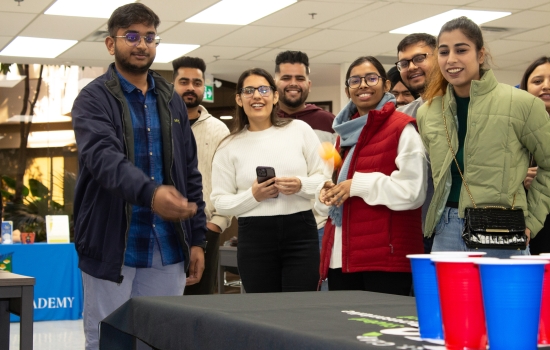 A student prepares to take his shot while others watch and smile