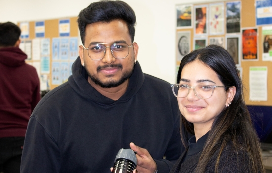 A student receives a free SRC water bottle from Sakshi