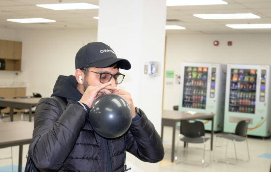 A student blows up their balloon 