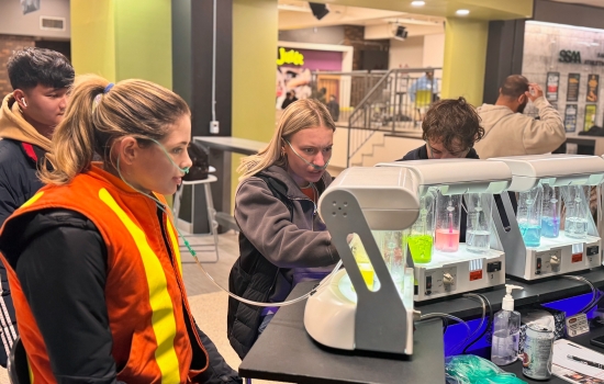 3 students try the oxygen bar, one wearing a high visibility vest