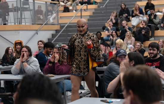 Sabin holds a microphone and interacts with the crowd in the SLC
