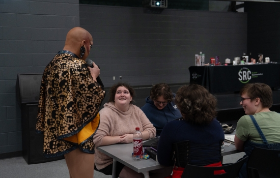 Sabin holds a microphone and interacts with the crowd in the SLC
