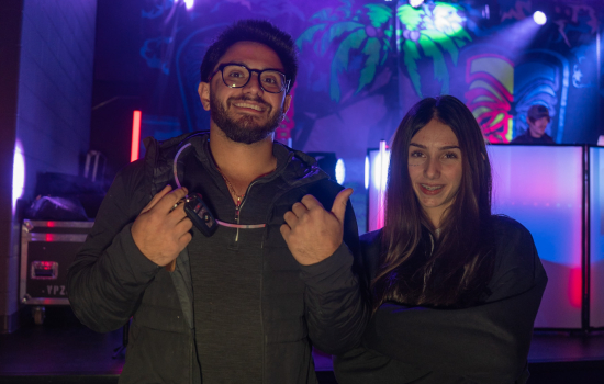 Two students smile in front of the stage