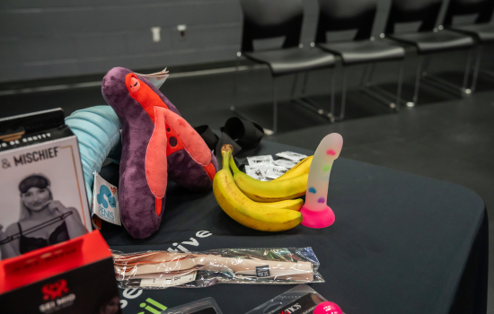 a table full of sex toy prizes, a plush vulva and bananas