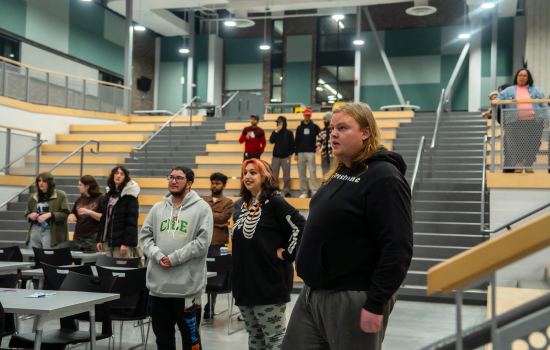Students stand in the SLC and engage with the speaker