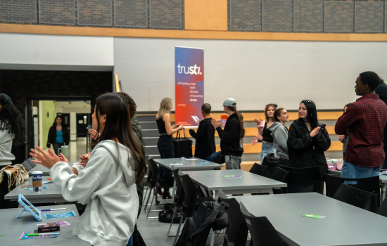 Students stand in the SLC and engage with the speaker