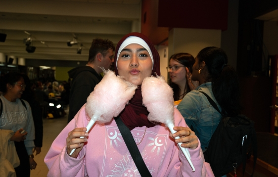 A student poses with 2 cotton candy cones